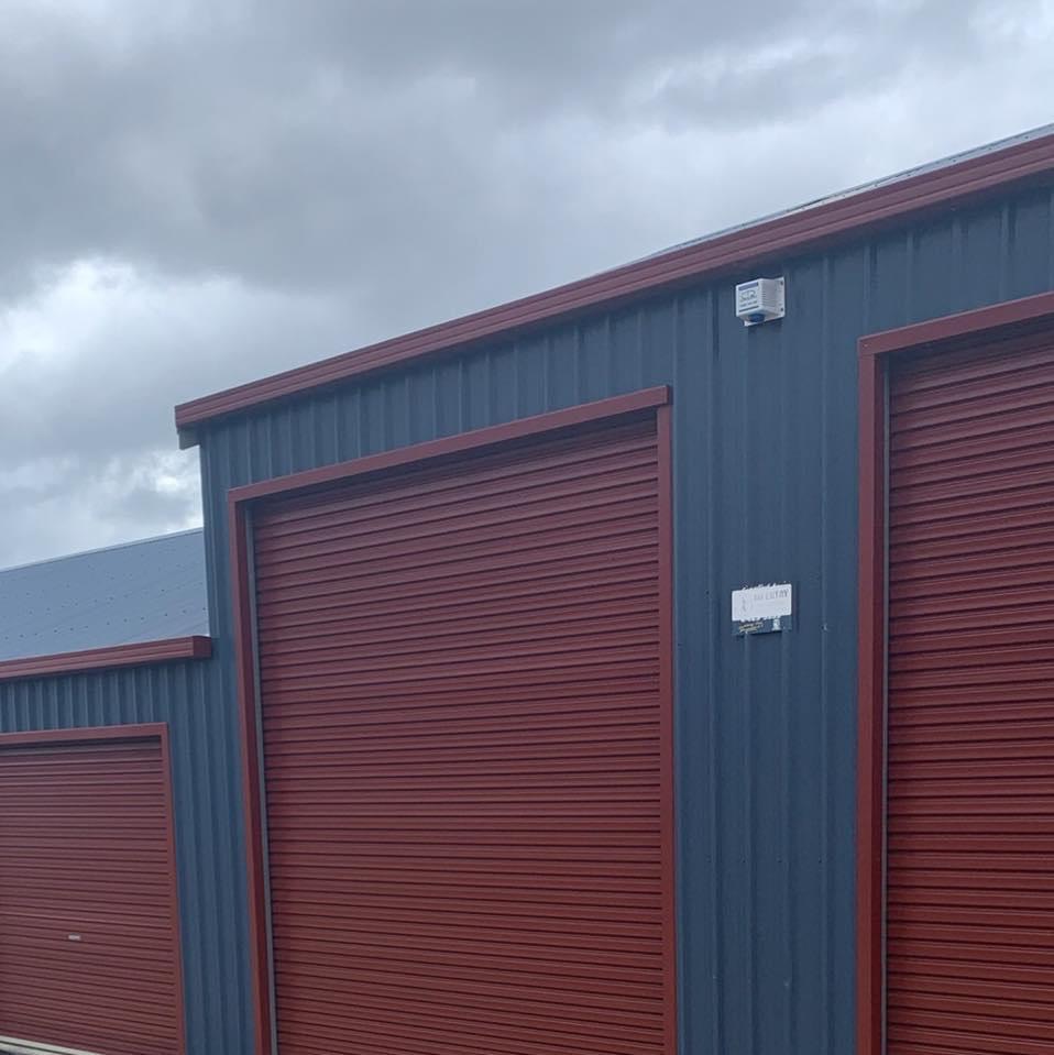 The workshop building on Don Road, navy walls with oxide red roller doors